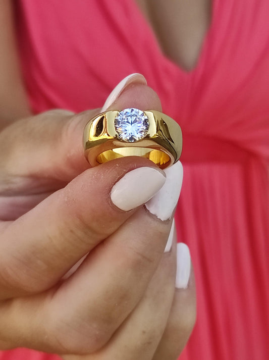 May include: A gold ring with a large, round, clear gemstone