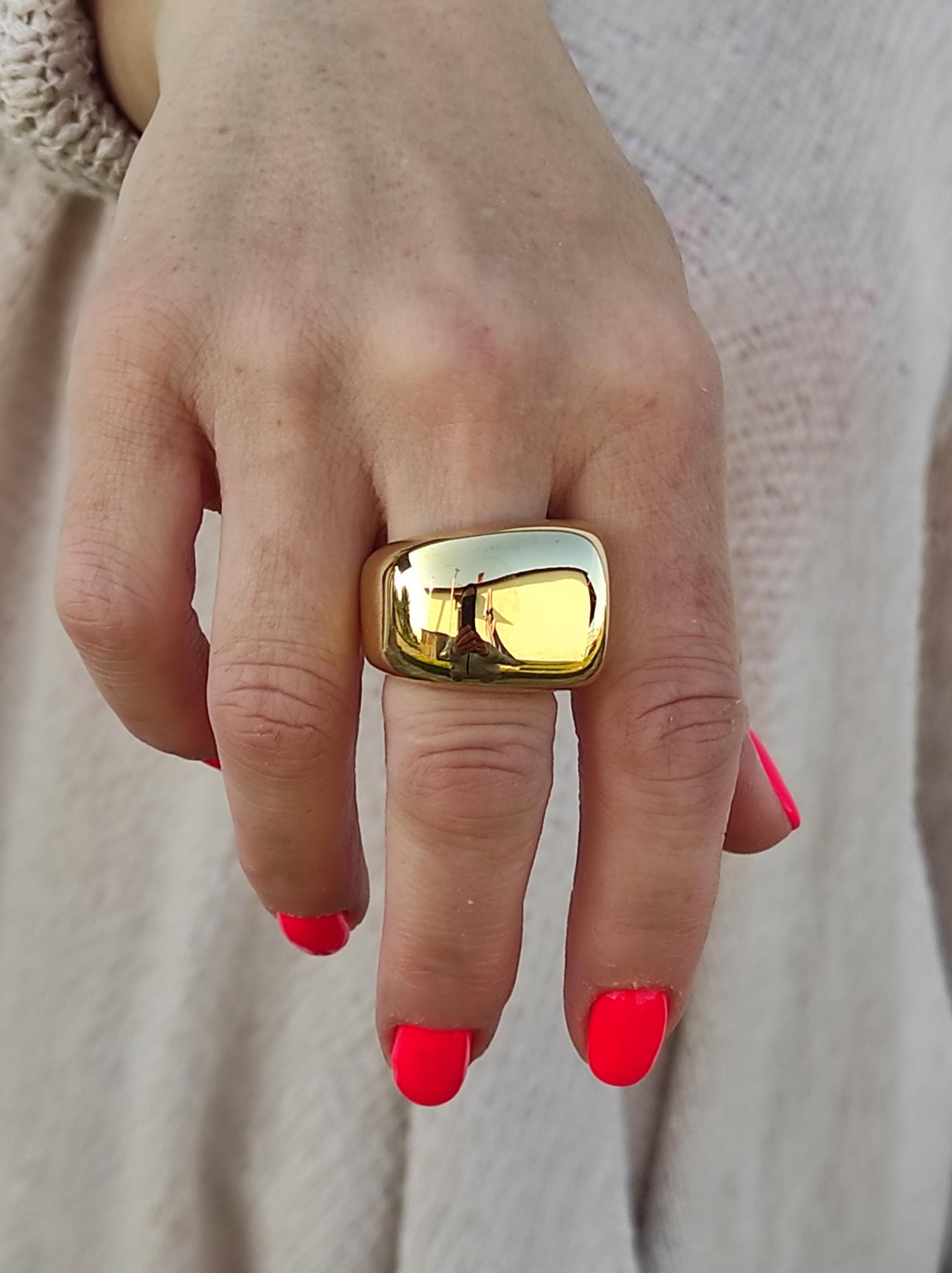 May include: A gold square ring with a smooth, shiny surface.