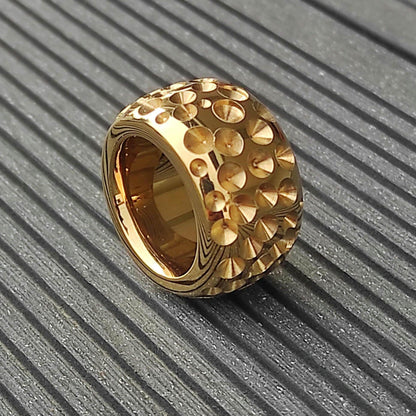 May include: A gold-toned ring with a textured surface. The ring is made of many small, raised circles.