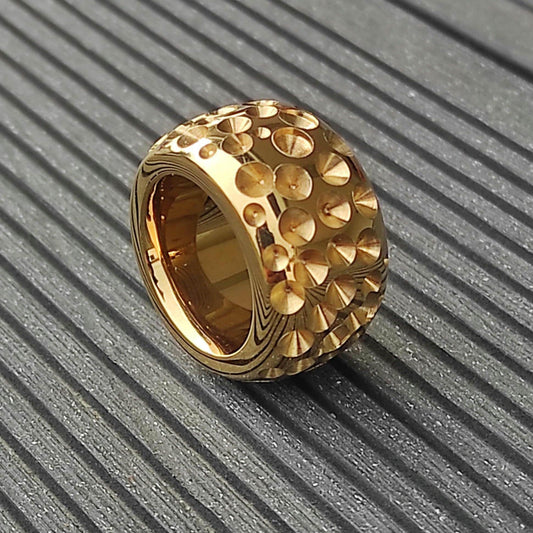 May include: A gold-toned ring with a textured surface. The ring is made of many small, raised circles.
